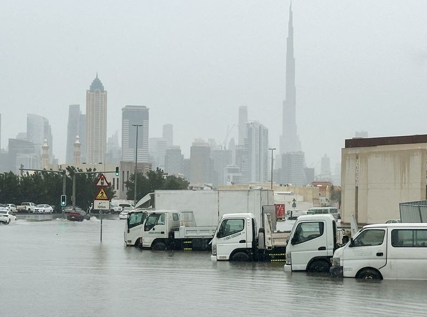 Vehicles stand in flood water caused by heavy rains with the Burj Khalifa tower visible in the background, in Dubai, United Arab Emirates, March 9, 2024. REUTERS/Abdelhadi Ramahi