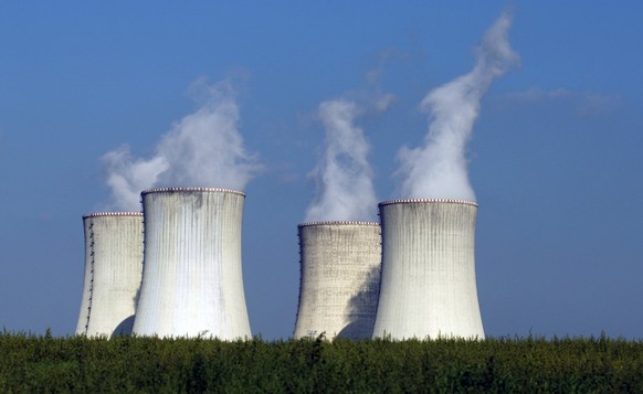 FILE - Four of the cooling towers of the Dukovany nuclear power plant rise high above the natural surroundings of Dukovany, Czech Republic, Sept. 27, 2011. All three energy companies that passed a Cze ...