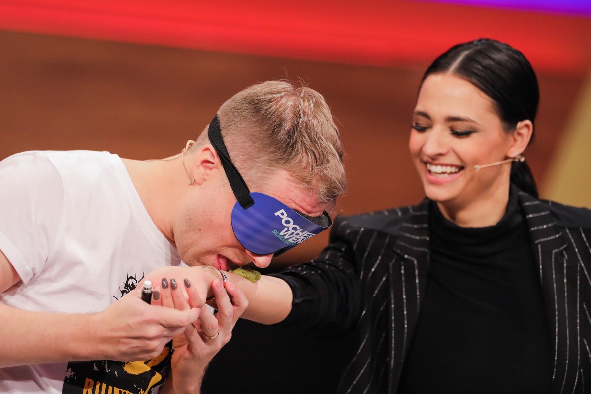 ARCHIV - 01.03.2020, Nordrhein-Westfalen, H�rth: Oliver Pocher (l), Moderator, muss in der Live-Show �Pocher vs. Wendler - Schluss mit lustig!� bei RTL Essen vom Arm seiner Frau Amira lecken. (zu dpa ...