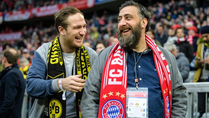 31.03.2018, Bayern, München: Fußball, Bundesliga, Bayern München - Borussia Dortmund, 28. Spieltag in der Allianz Arena: Die Schauspieler Frederick Lau (l) und Kida Ramadan unterhalten sich vor Spielb ...