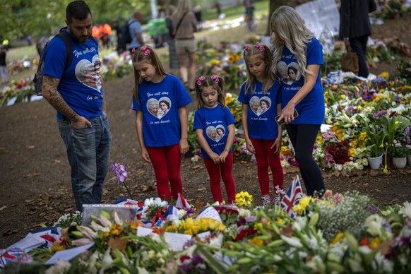 FILE - Jamie and Emma with their daughters, from second left, Maisie, Arabella and Elithia, stand next to flowers and messages placed for Queen Elizabeth II at Green Park memorial next to Buckingham P ...