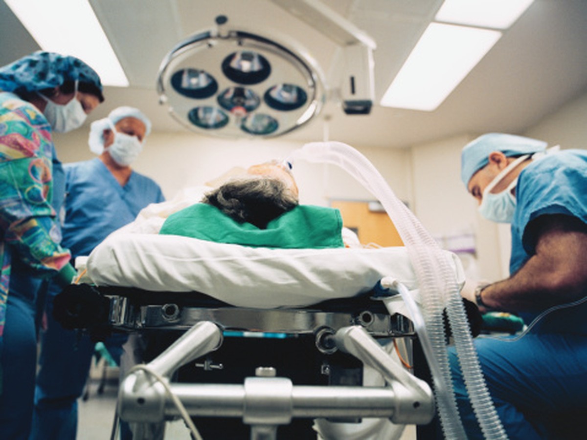 Surgeon and nurses standing next to bed