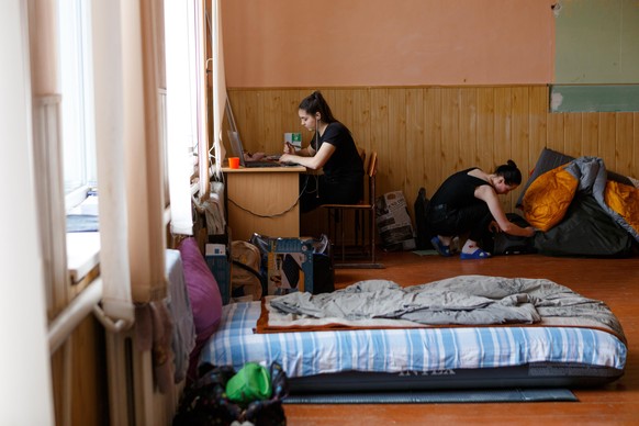 Two schoolgirls watch online lessons from a shelter in Perechyn, Ukraine.