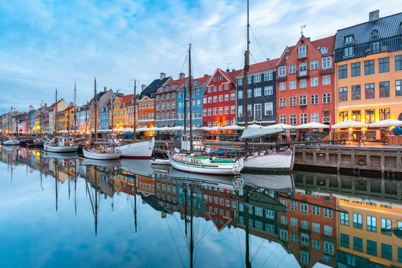 Nyhavn with colorful facades of old houses and old ships in the Old Town of Copenhagen, capital of Denmark.