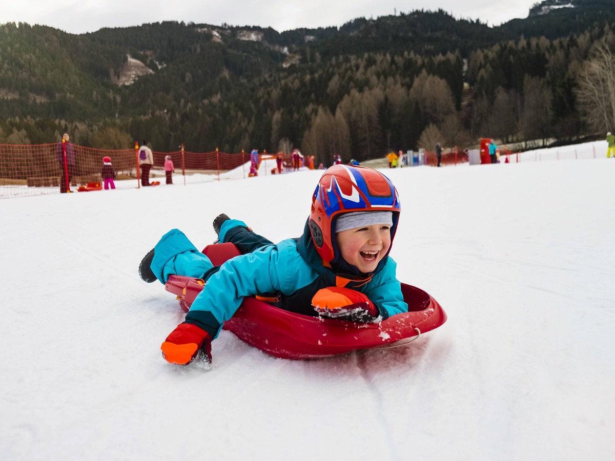 Italy, Trentino-Alto Adige, happy boy on tobogganing plastic sledge model released Symbolfoto PUBLICATIONxINxGERxSUIxAUTxHUNxONLY MGIF00323