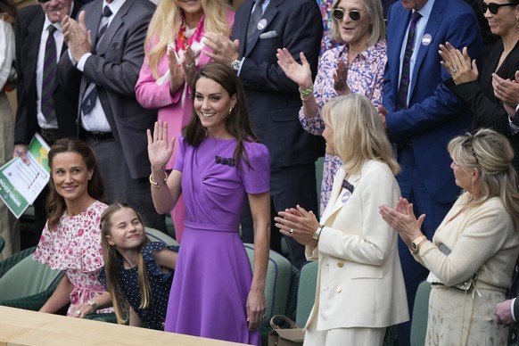 Kate, Princess of Wales waves to the crowd from the Royal Box, with her daughter Princess Charlotte, and her sister Pippa Matthews, left, looks on ahead of the men&#039;s singles final at the Wimbledo ...