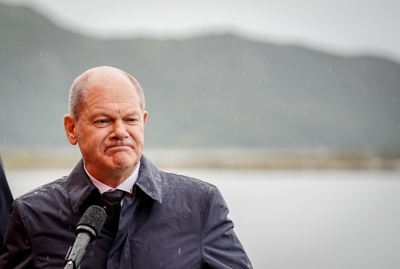23.08.2022, Kanada, Stephenville: Bundeskanzler Olaf Scholz (SPD) steht bei einer Pressekonferenz neben dem kanadischen Premierminister in Neufundland im Regen. Im Mittelpunkt der Reise steht die Zusa ...