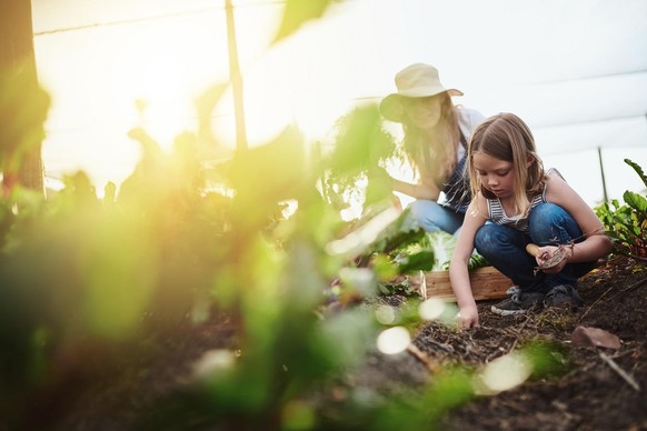 Full length shot of a young mother and her little daughter working on the family farm