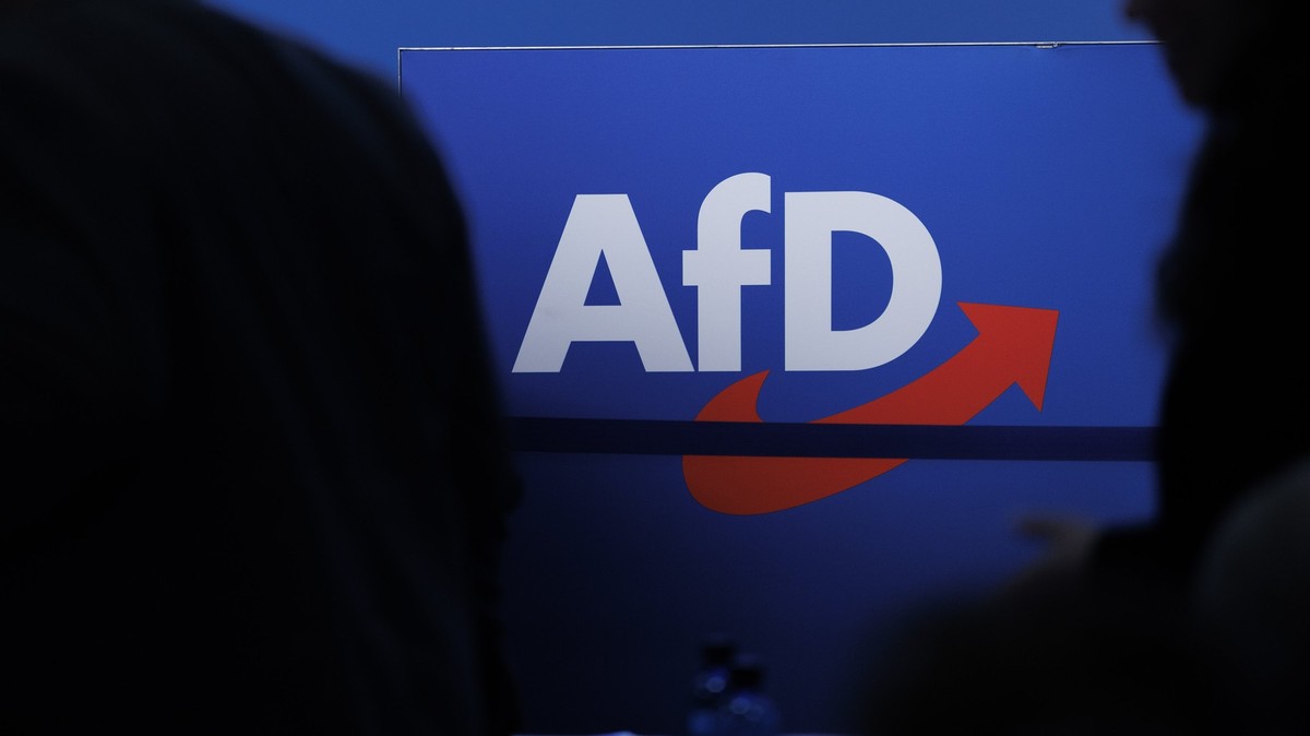 ARCHIV - 28.07.2023, Sachsen-Anhalt, Magdeburg: Delegierte gehen vor dem Parteilogo bei dem AfD-Bundesparteitag in Magdeburg. (zu dpa: «Verfassungsschutz: AfD ist gesichert rechtsextremistisch») Foto: ...
