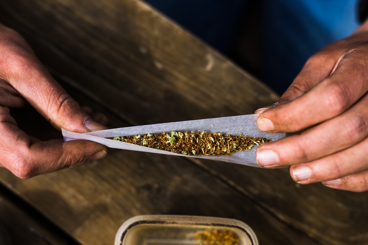 ARCHIV - 17.04.2023, Baden-Württemberg, Heitersheim: Ein Mann dreht sich mit Cannabis und Tabak einen Joint. (zu dpa: «Wiesbaden startet Pilotprojekt für Cannabis-Tests in Clubs») Foto: Philipp von Di ...