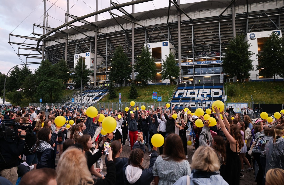 23.07.2024, Hamburg: Fans singen und tanzen beim Konzert der US-Sängerin Taylor Swift vor dem Volksparkstadion. Es ist das vierte Deutschland-Konzert im Rahmen ihrer «The Eras Tour». Foto: Christian C ...