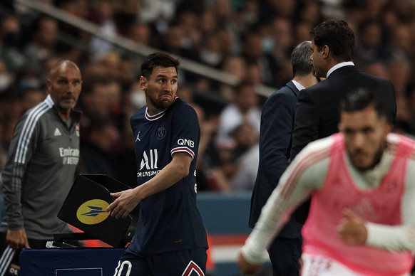 Lionel Messi (M.) schaut seinen Trainer Mauricio Pochettino (rechts im Anzug) verwundert an.
