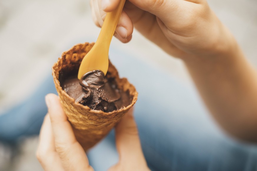 Woman s hand holding ice cream cone with cholocolate ice, close-up model released Symbolfoto PUBLICATIONxINxGERxSUIxAUTxHUNxONLY JSCF00136