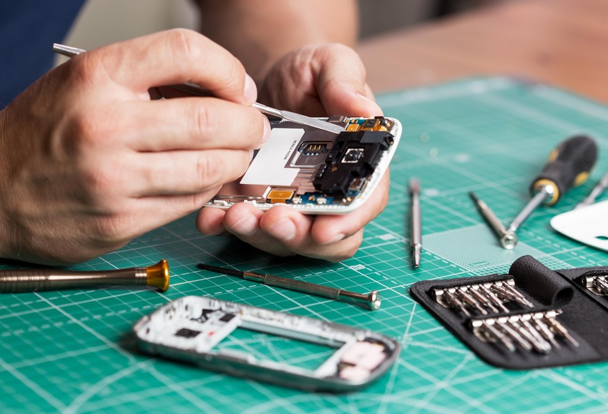 Man repairing broken smartphone, close up photo.