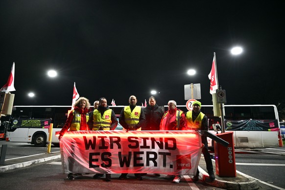 01.03.2024, Nordrhein-Westfalen, Köln: Streikende stehen hinter einem Plakat mit der Aufschrift «Wir sind es wert.». Am Freitag findet ein bundesweiter PNV-Warnstreik von Verdi in Kooperation mit Frid ...