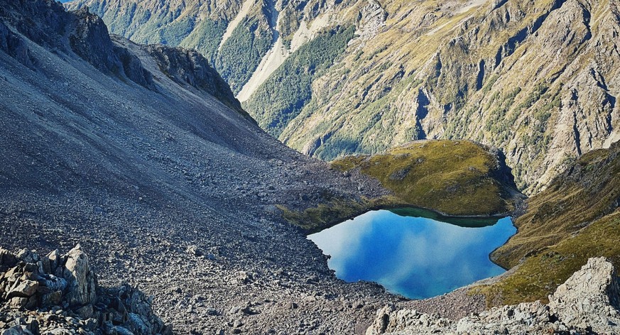 The rugged mountains, crystal-clear lake, and bright sky create a breathtaking scene at Nelson Lakes National Park in New Zealand 25557162 RECORD DATE NOT STATED