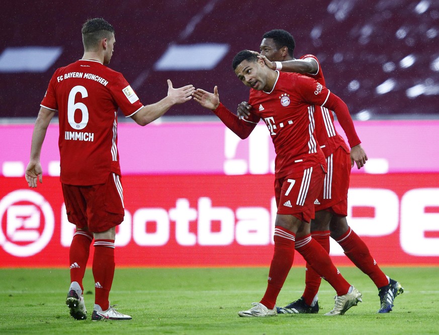 MUNICH, GERMANY - JANUARY 30: Serge Gnabry of FC Bayern Munich celebrates with team mates Joshua Kimmich and David Alaba after scoring their side&#039;s fourth goal past Oliver Baumann of TSG 1899 Hof ...