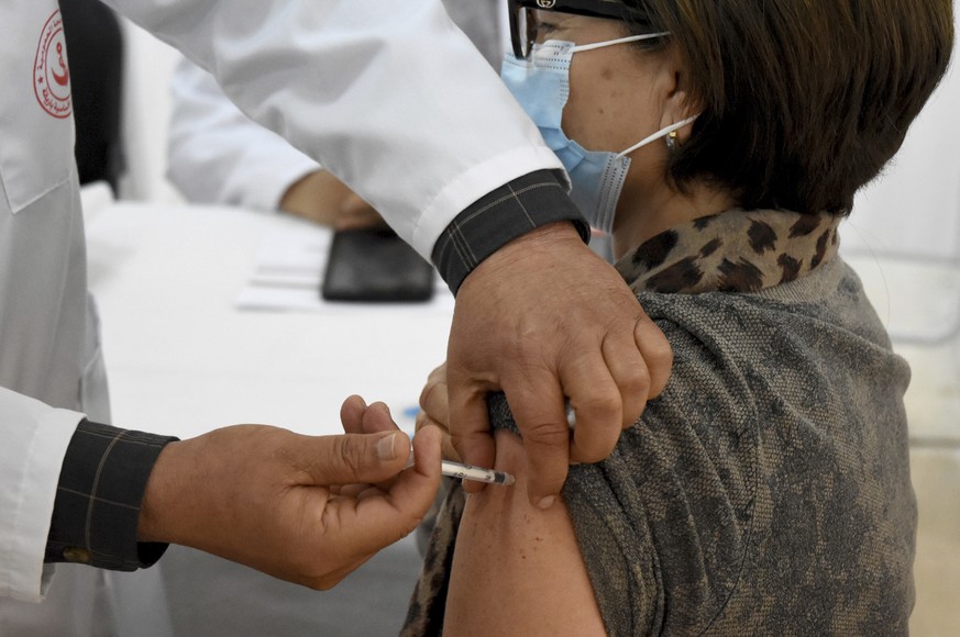 A woman receives the Sputnik-V COVID-19 vaccine at the Ariana hospital, in Tunis Tunisia, Saturday, March 13, 2021. Tunisia launched its vaccination campaign on Saturday, after receiving the first 30, ...