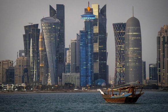 FILE - A traditional dhow boat sails towards the West Bay in Doha, Qatar, Thursday, Nov. 25, 2021. Although Qatar has sought to portray itself as welcoming to foreigners, traditional Muslim values rem ...