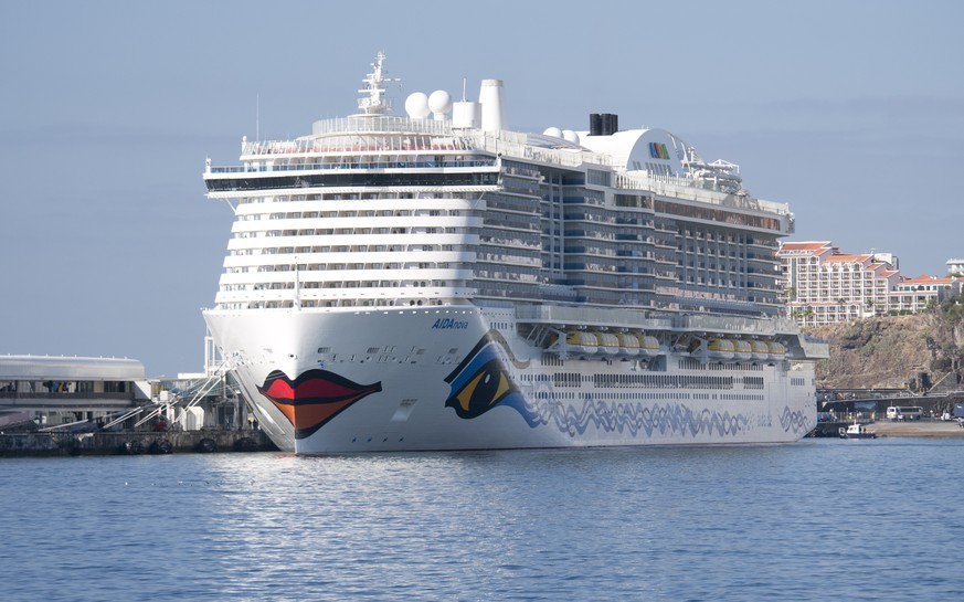 The AIDA Nova cruise ship in Funchal Harbour against a blue sky and a blue sea.