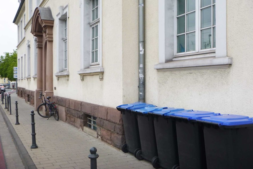 Dokumente achtlos entsorgt: Fünf blaue Mülltonnen vor dem Jobcenter in der Gütersloher Kaiserstraße.