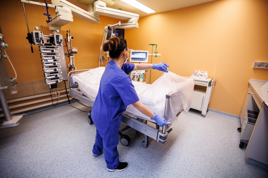 Eine Krankenschwester bedeckt in einem Intensivbett-Zimmer in der Asklepios Klinik ein für einen Patienten vorbereitetes Bett mit einer Folie.