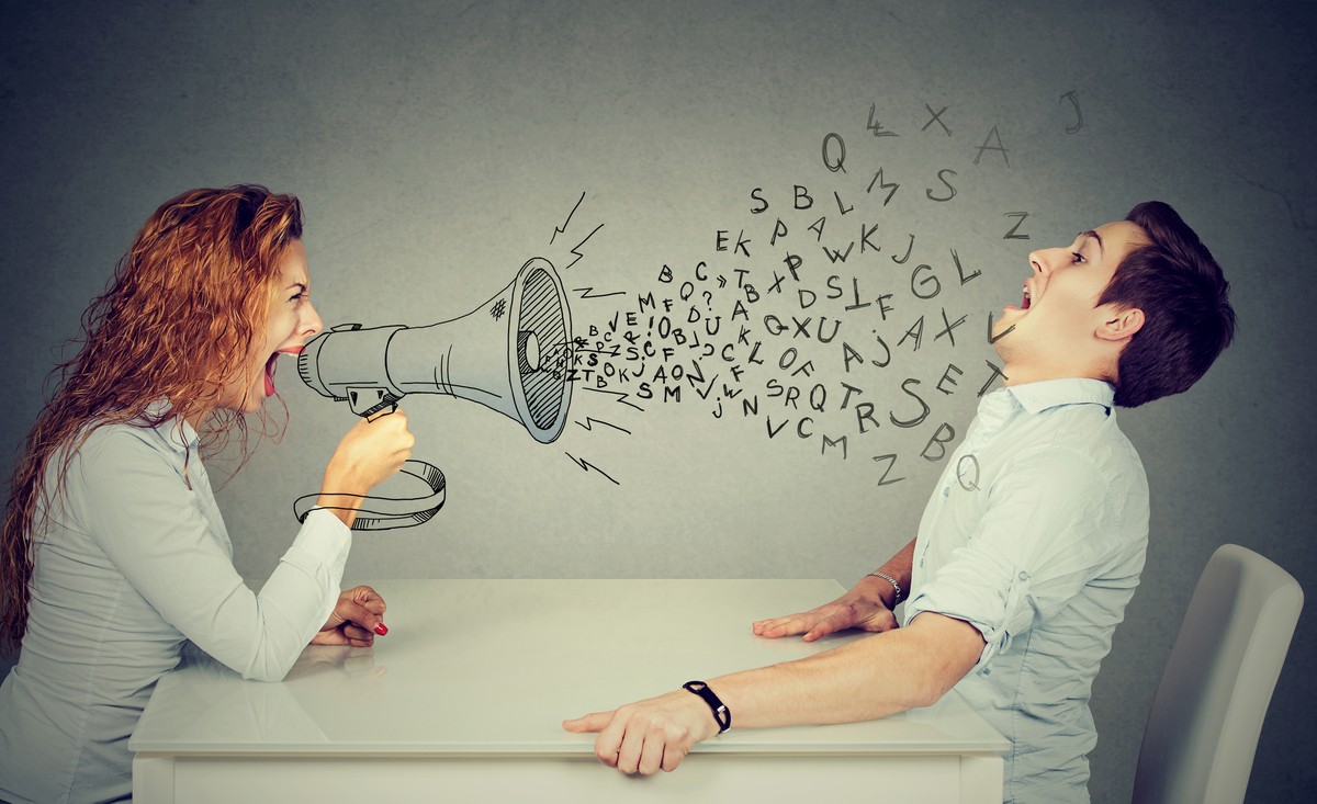 angry young woman with megaphone shouting at stressed scared man blown away by wave of alphabet letters