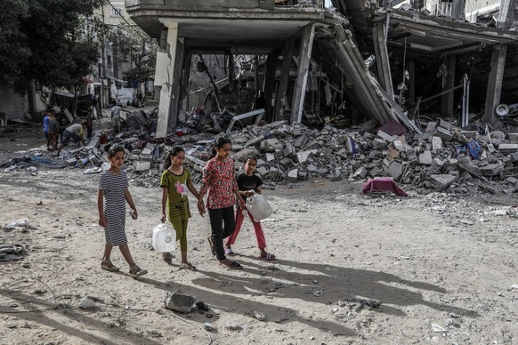 dpatopbilder - 25.04.2024, Palästinensische Gebiete, Rafah: Inmitten des anhaltenden Konflikts zwischen Israel und der islamistische Hamas gehen palästinensische Kinder neben einem zerstörten Haus nac ...
