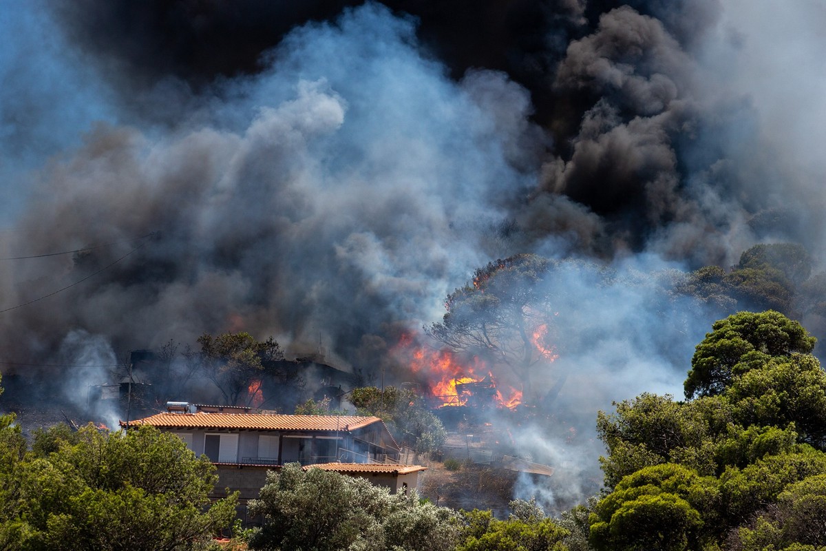 30.06.2024, Griechenland, Keratea: Rauch steigt von einem Waldbrand in der N�he von H�usern in Keratea, s�d�stlich von Athen, Griechenland, auf. Seit dem Beginn der Waldbrandsaison am 1. Mai werden di ...