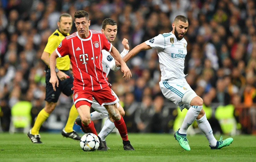 Champions League: Robert Lewandowski (Bayern München) behauptet den Ball gegen Spieler von Real Madrid.