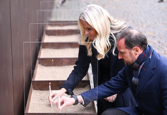 09.11.2023, Berlin: Der norwegische Kronprinz Haakon und seine Frau Kronprinzessin Mette-Marit zünden Kerzen bei der Zentralen Gedenkveranstaltung des 34. Jahrestags des Mauerfalls an der Gedenkstätte ...