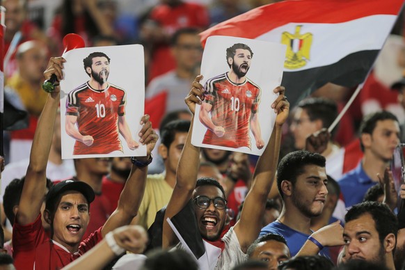 Soccer fans hold poster of Egyptian national soccer team player and Liverpool&#039;s star striker Mohammed Salah during Egypt&#039;s final practice for the World Cup soccer tournament at Cairo Stadium ...