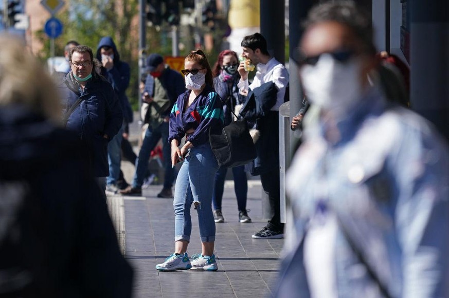 LEIPZIG, GERMANY - APRIL 20: People wearing protective face masks wait for a street tram on the first day face masks became compulsory on public transport in the state of Saxony during the novel coron ...