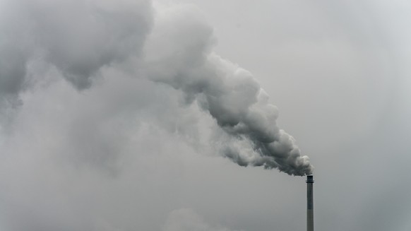ARCHIV - 09.10.2012, Bayern, Plattling: Qualm steigt aus dem Schornstein einer Fabrik. Im Kampf gegen die Klimakrise sollen die Treibhausgasemissionen in der EU nach Ansicht der Europ