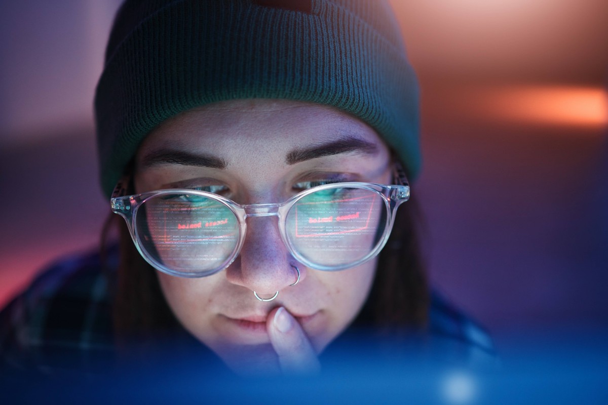 Cyber security, ransomware and woman hacker working on a computer in the basement at night for phishing. Database, password and malware with a female coder hacking a digital transformation network Cyb ...