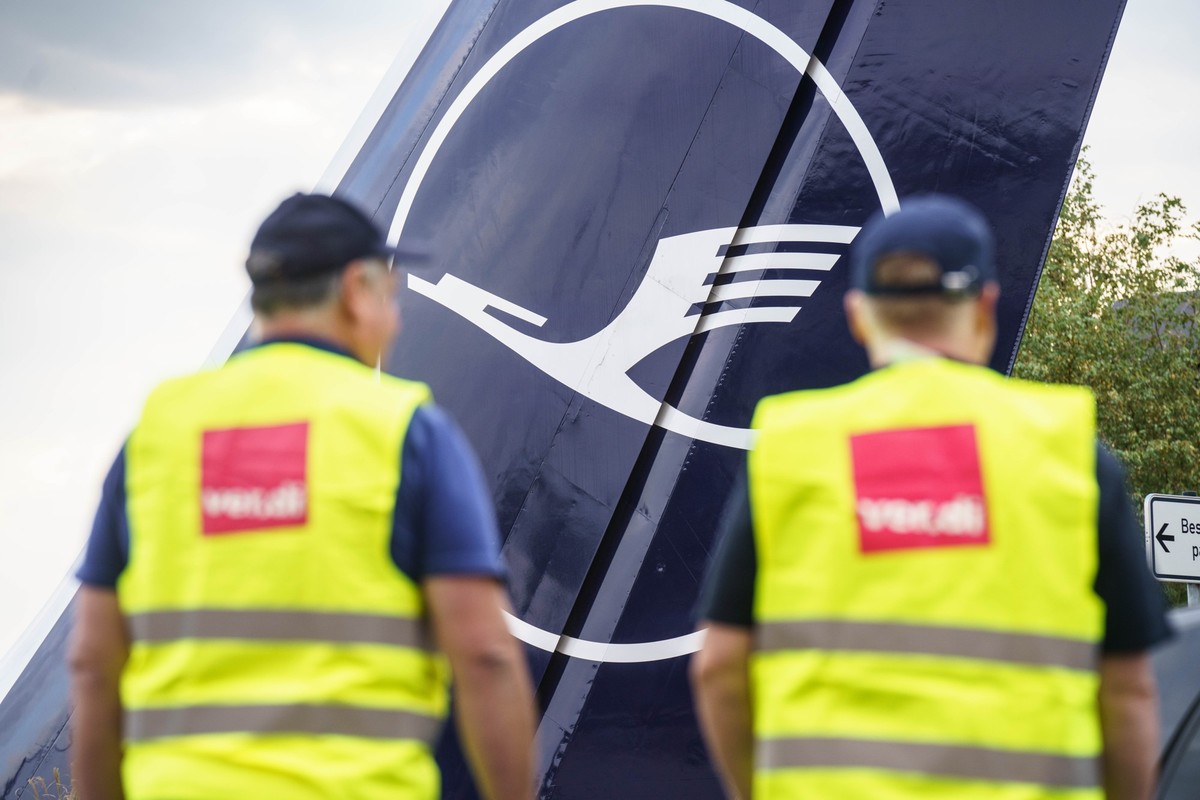 ARCHIV - 27.07.2022, Hessen, Frankfurt/Main: Zwei Verdi-Mitglieder stehen am Morgen am Frankfurter Flughafen am Eingang zur Lufthansa-Basis. (zu dpa "Im Lufthansa-Konzern steigt schon wieder die ...