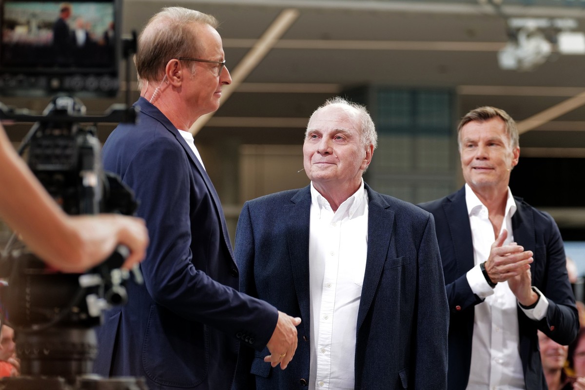 07.09.2025, Bayern, München: Die Moderatoren Florian König (l) und Thomas Helmer (r) unterhalten sich mit FC Bayern Ehrenpräsident Uli Hoeneß (M) während der Jubiläumssendung 30 Jahre «Doppelpass», au ...