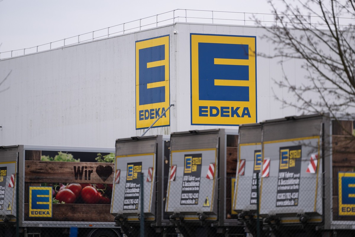ARCHIV - 10.03.2024, Brandenburg, Gr�nheide: Vor einem Logistikzentrum der Handelskette Edeka stehen mehrere LKW. (zu dpa: �Edeka steigert Umsatz auf mehr als 70 Milliarden Euro�) Foto: Christophe Gat ...