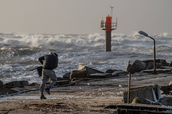 A person struggles through the wind out of Thorsminde Harbour at the west coast of Jutland, Denmark, Thursday December 21, 2023. The storm Pia is expected to culminate Thursday evening and Friday nigh ...