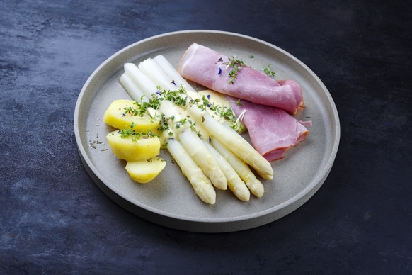Traditional steamed white asparagus with juniper ham and boiled potato in hollandaise sauce served as a close-up on a design plate with text space Model Released Property Released xkwx Asparagus white ...