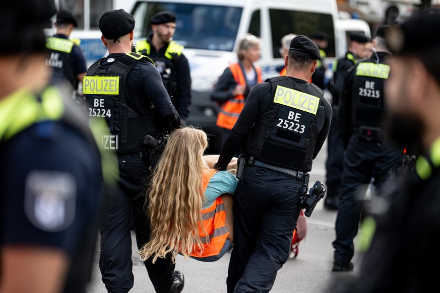 23.09.2023, Berlin: Polizisten räumen Teilnehmer einer Demonstration der Klimaschutzgruppe Letzte Generation auf der Potsdamer Straße, die die Straße blockieren. Foto: Fabian Sommer/dpa +++ dpa-Bildfu ...