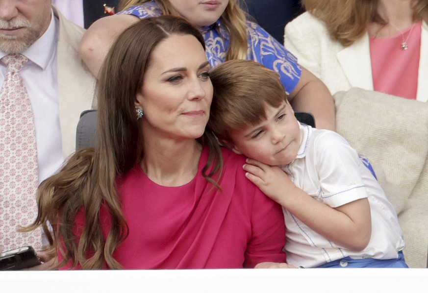 Prince Louis leans on Kate, Duchess of Cambridge, during the Platinum Jubilee Pageant held outside Buckingham Palace, in London, Sunday June 5, 2022, on the last of four days of celebrations to mark t ...