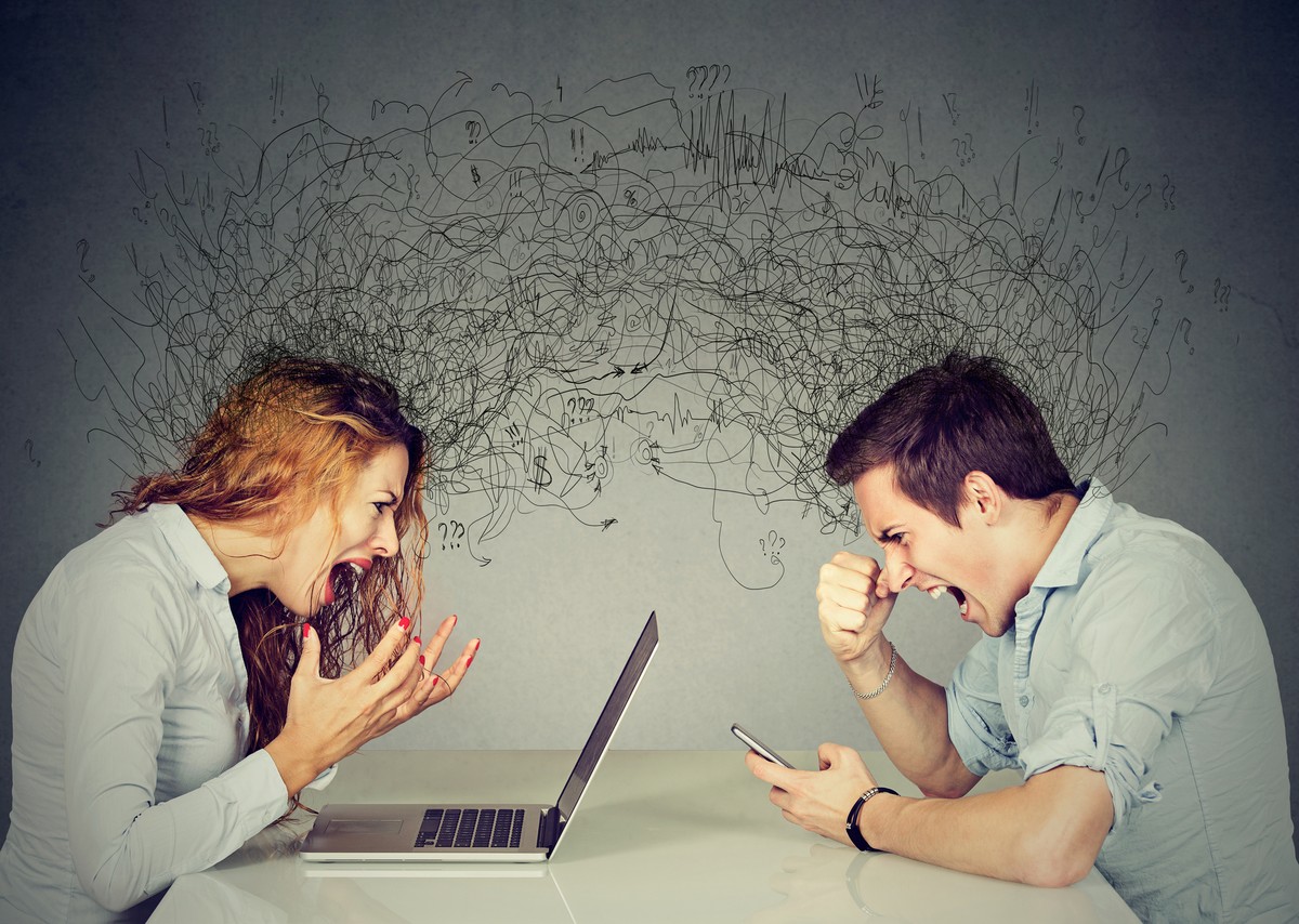 Stressed business woman screaming at laptop sitting at table across angry man shouting at mobile phone exchanging with clutter of negative thoughts and emotions. Distant relationship concept