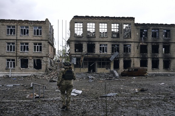 ARCHIV - 25.04.2023, Ukraine, Awdijiwka: Ein ukrainischer Soldat geht an dem Schauplatz schwerer Kämpfe mit russischen Truppen in der Region Donezk. (zu dpa: «Ukrainer graben sich bei Awdijiwka auf ne ...