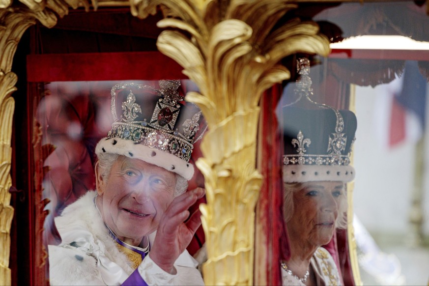 dpatopbilder - 06.05.2023, Großbritannien, London: Großbritanniens König Charles III. und Königin Camilla fahren nach der Krönungszeremonie mit der Goldenen Staatskutsche, dabei grüßt charles III. die ...