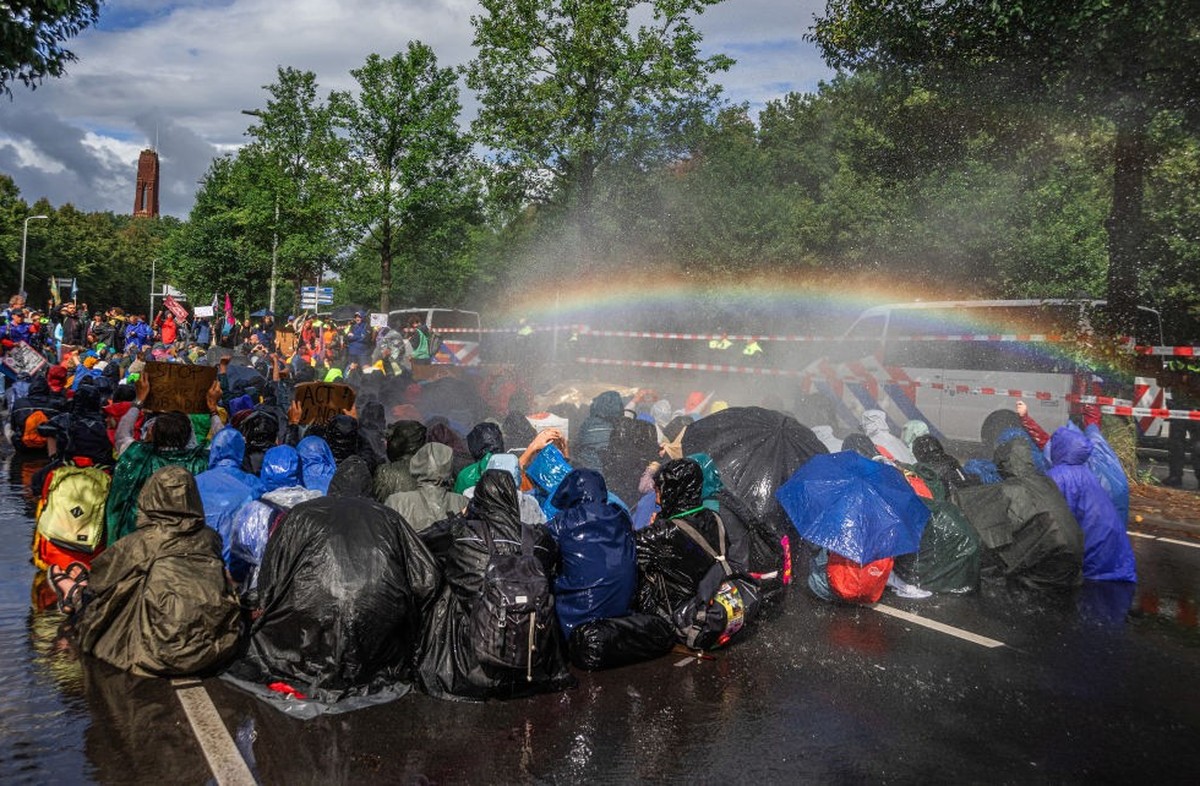 THE HAGUE, NETHERLANDS - 2023/09/23: Extinction Rebellion climate activists sit under water canon during the non-violent sit-down demonstration. Today&#039;s non-violent sit-down demo on the Utrechtse ...