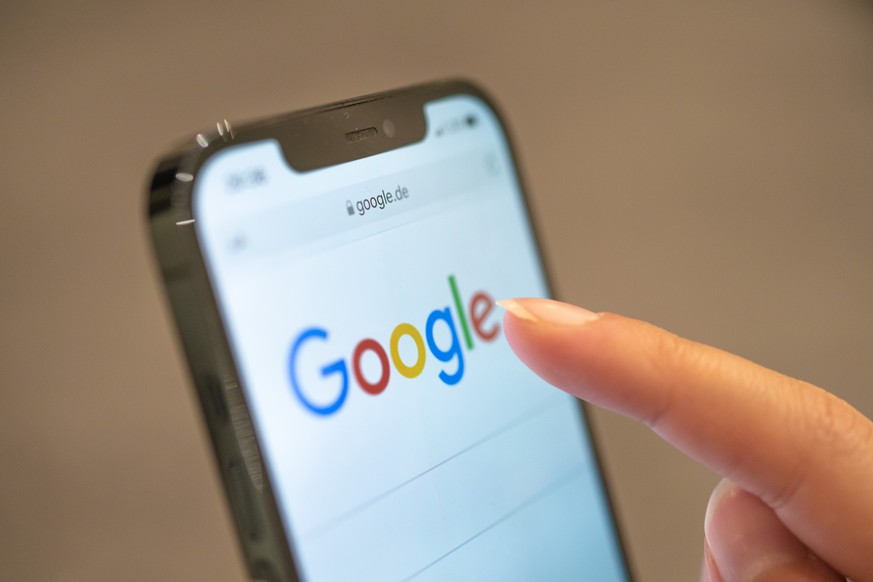 ARCHIV - 24.11.2021, Niedersachsen, Oldenburg: Eine Frau hält ihr Handy in der Hand, auf dem die Google-Seite im Browser zu sehen ist. Vor 25 Jahren wurden die Weichen dafür gestellt, dass «googeln» z ...