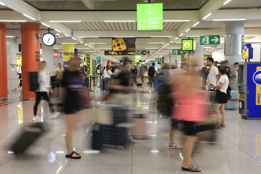 dpatopbilder - 30.07.2023, Spanien, Palma: Reisende gehen am Flughafen von Mallorca durch eine Halle. Am letzten Juli-Wochenende war das Passagieraufkommen hier besonders hoch. Foto: Clara Margais/dpa ...