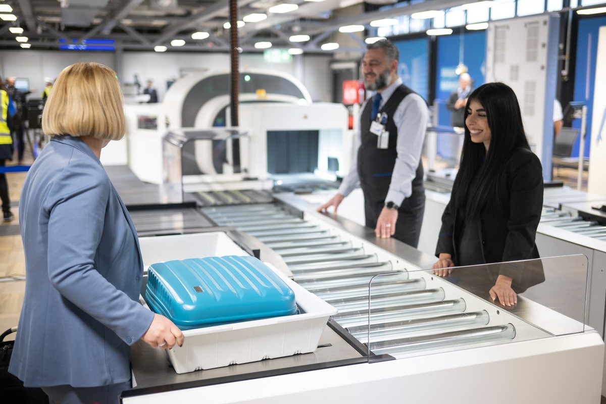 20.01.2023, Hessen, Frankfurt/Main: Eine Frau legt w�hrend der Vorstellung von neuen Luftsicherheitskontrollen mit modernen CT-Scannern am Flughafen Frankfurt einen Koffer in eine Kiste an einem Scann ...