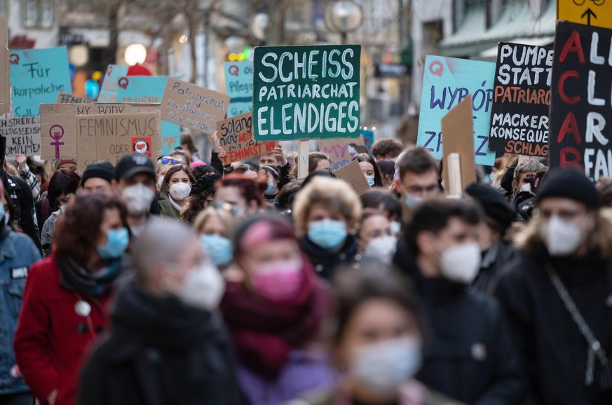 Eine Teilnehmerin einer Demonstration in Stuttgart zum Internationalen Frauentag 2021 trägt ein Plakat mit der Aufschrift &quot;Scheiss Patriarchat Elendiges&quot;